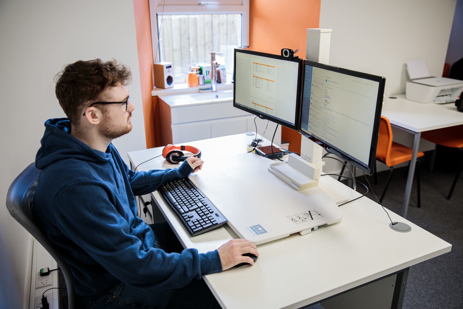 A man sat at a desktop computer working