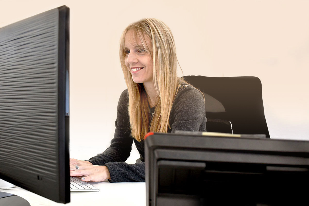 A lady smiling at her computer